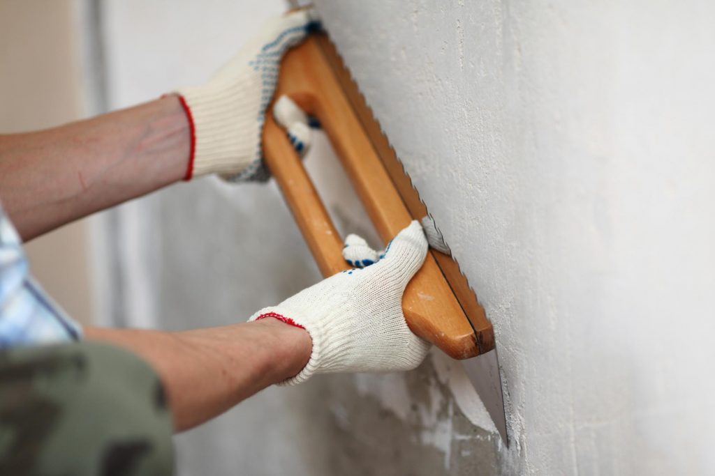 man smoothing the wall